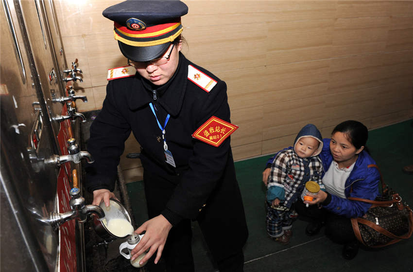 最美春运铁路人—襄阳站值班站长龚黎黎服务重点旅客,为孩子冲泡