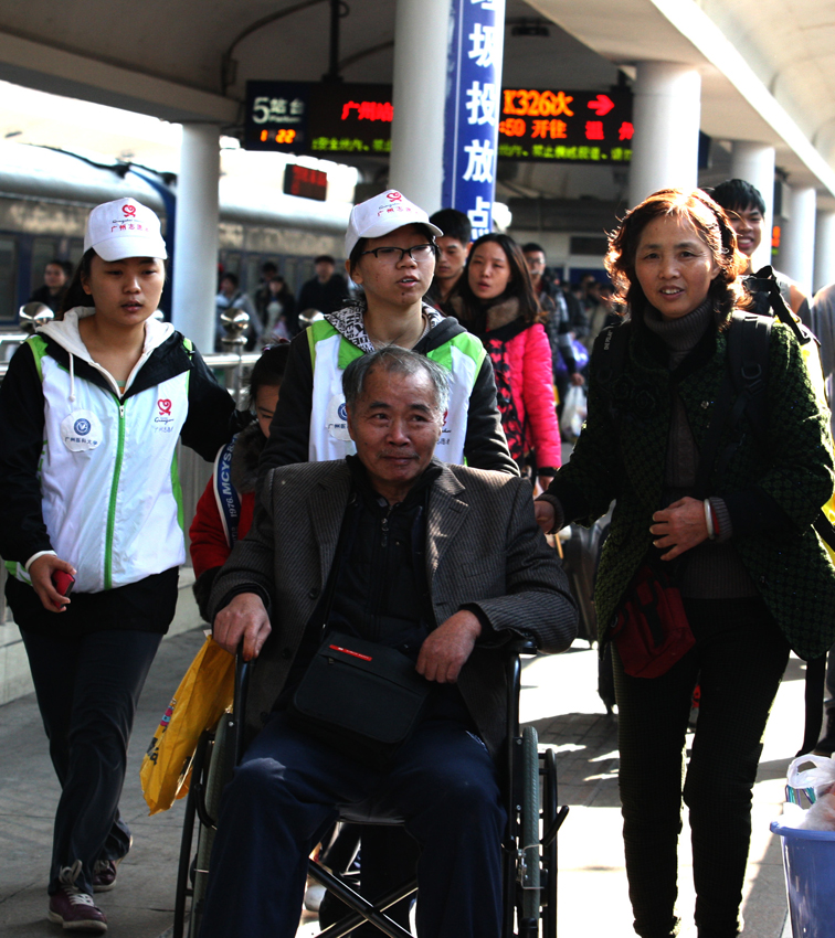 1月22日，志願者幫助一名行動不便的旅客   丁勇 攝